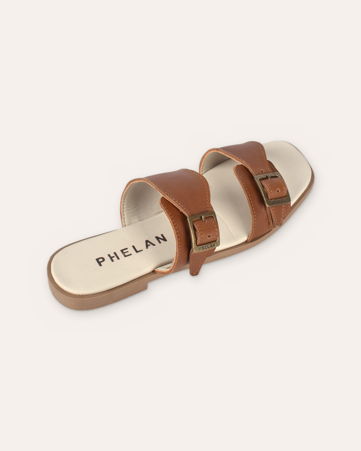 Buckle Sandal in Tan from the heel end, showing the PHELAN footbed