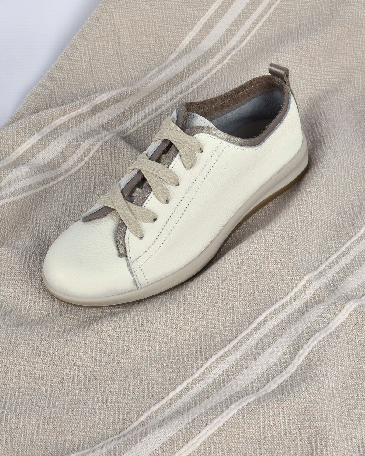 Hydra Sneaker in White/Pewter on an oatmeal striped throw