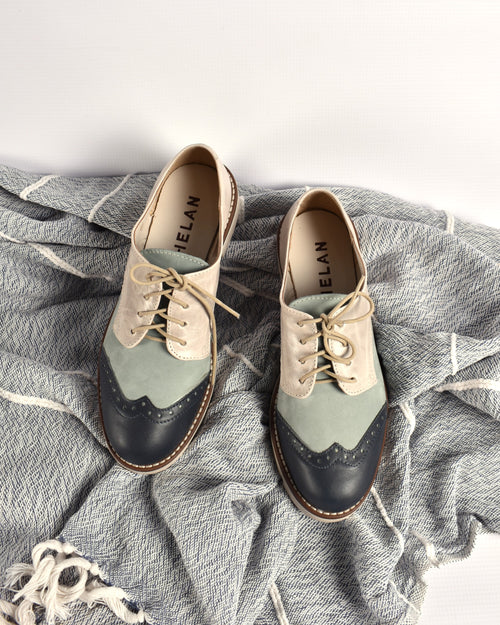 AVA BROGUE pair from above on a grey throw, navy, sky and fog leather