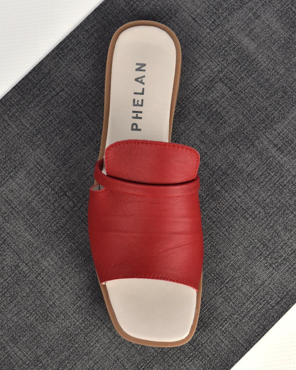 Ravello Slide in Red, one shoe from above on a charcoal mat