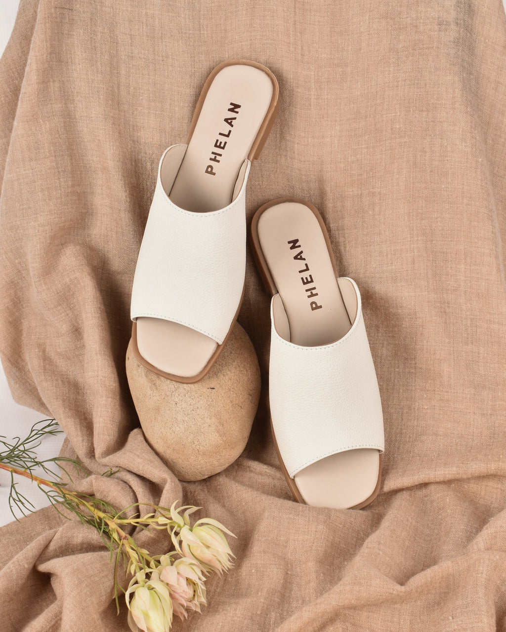 Mykonos Slide in White on a linen throw with a stone and fynbos