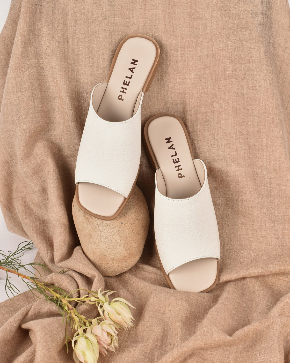 Mykonos Slide in White on a linen throw with a stone and fynbos