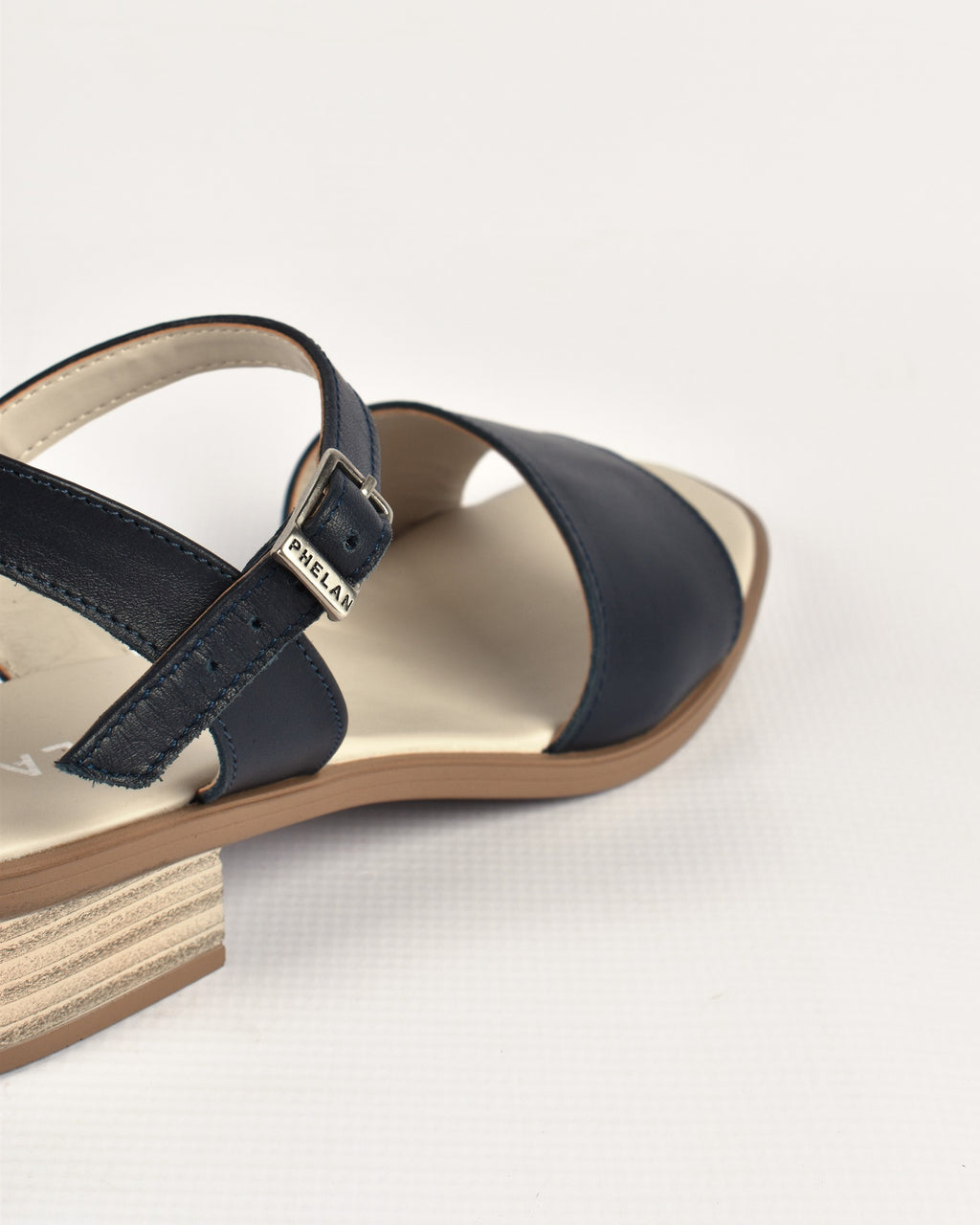 Stella Heel in Navy, close-up of the ankle strap and PHELAN buckle