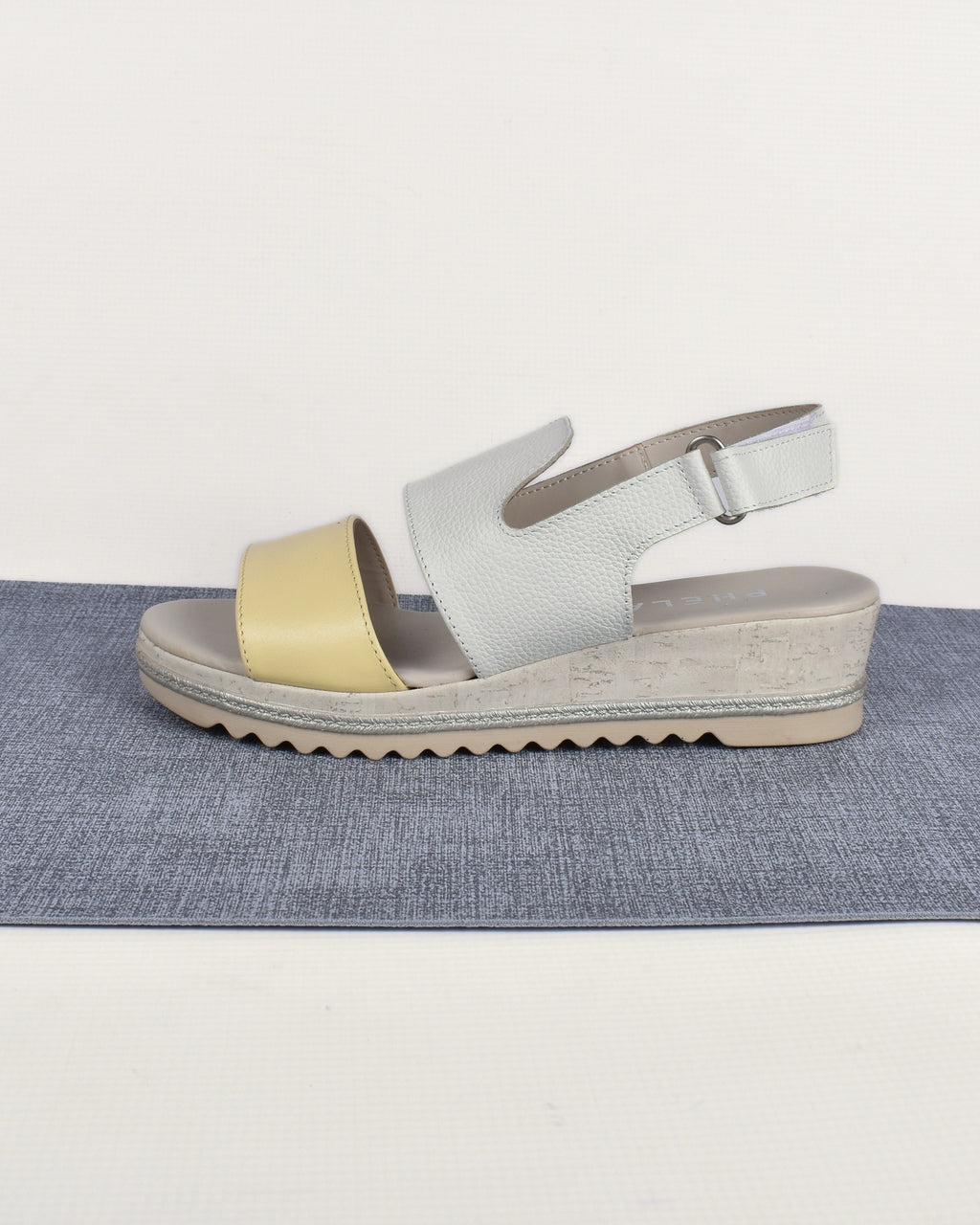 Sail Wedge in White/Yellow, side view on a blue-grey mat