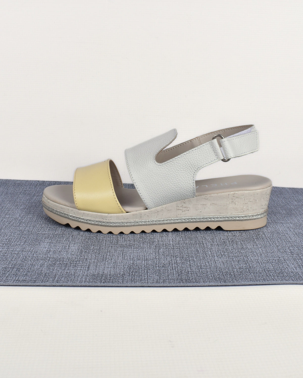 Sail Wedge in White/Yellow, side view on a blue-grey mat