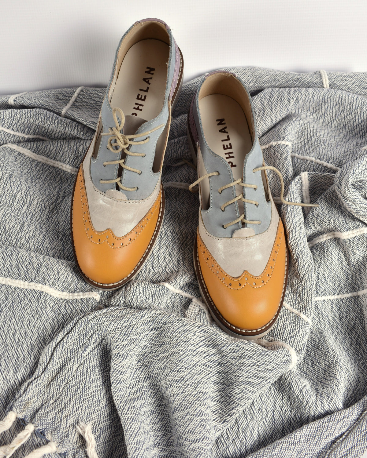 Darcy Brogue pair from above on a grey striped throw