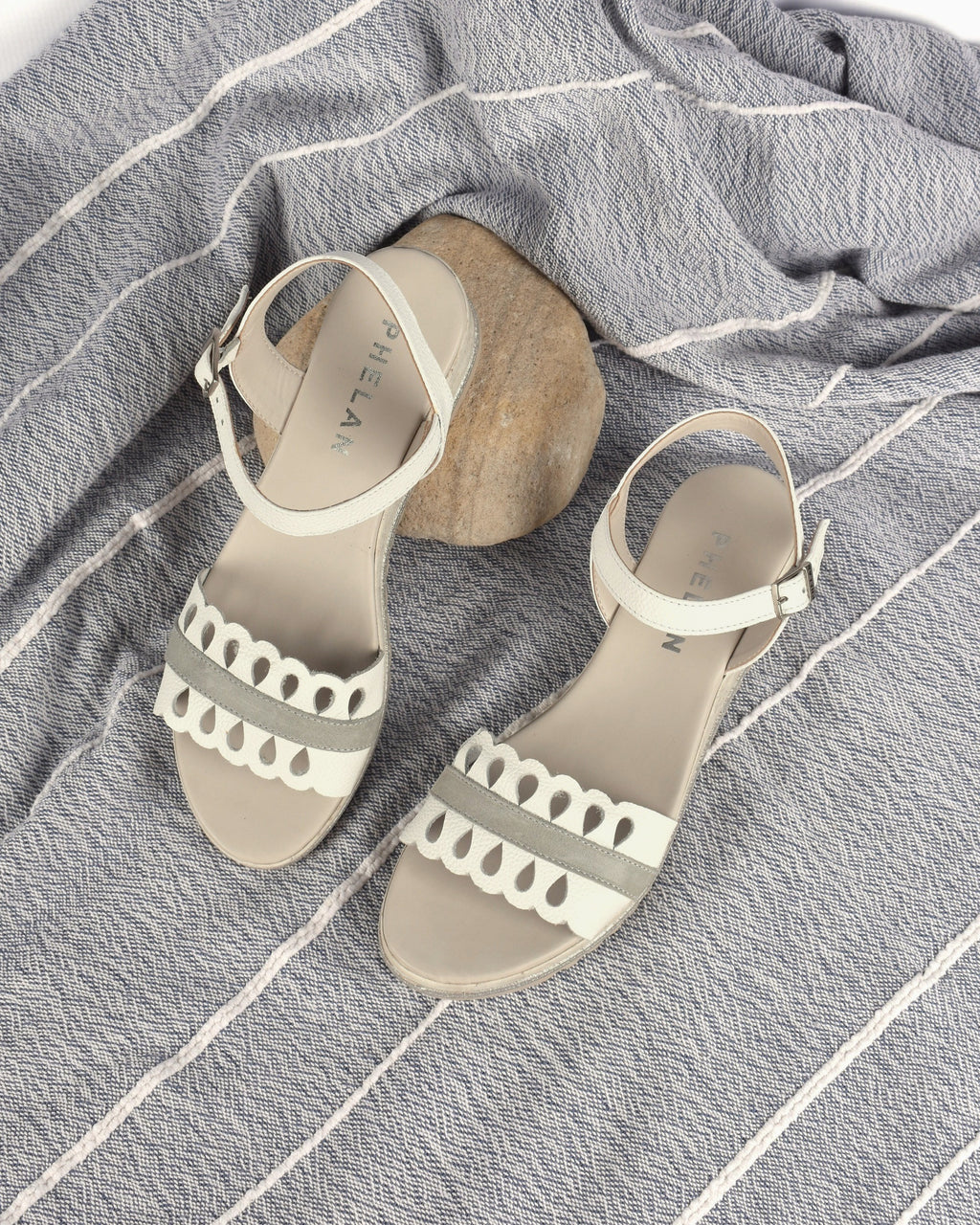 Dolly Wedge in White/Grey, the pair on a blue-grey throw