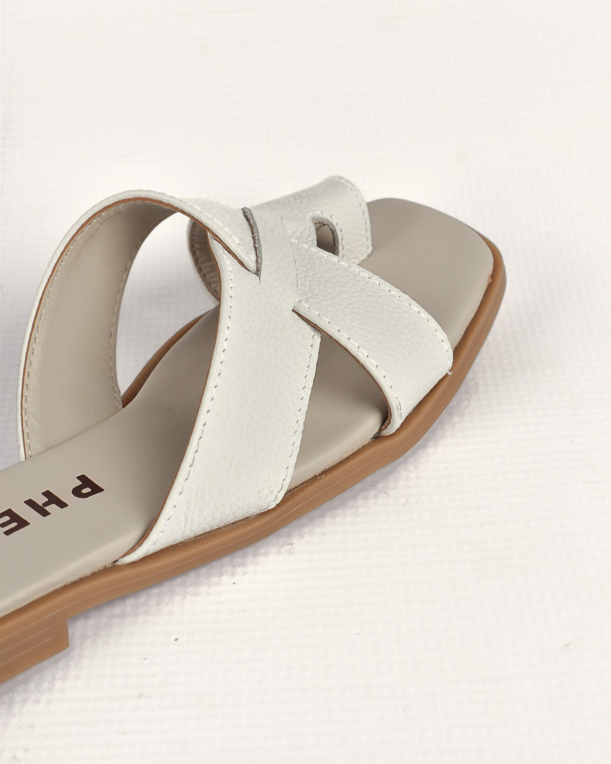 Isla Slide in White, close-up of the crossover bands and toe loop