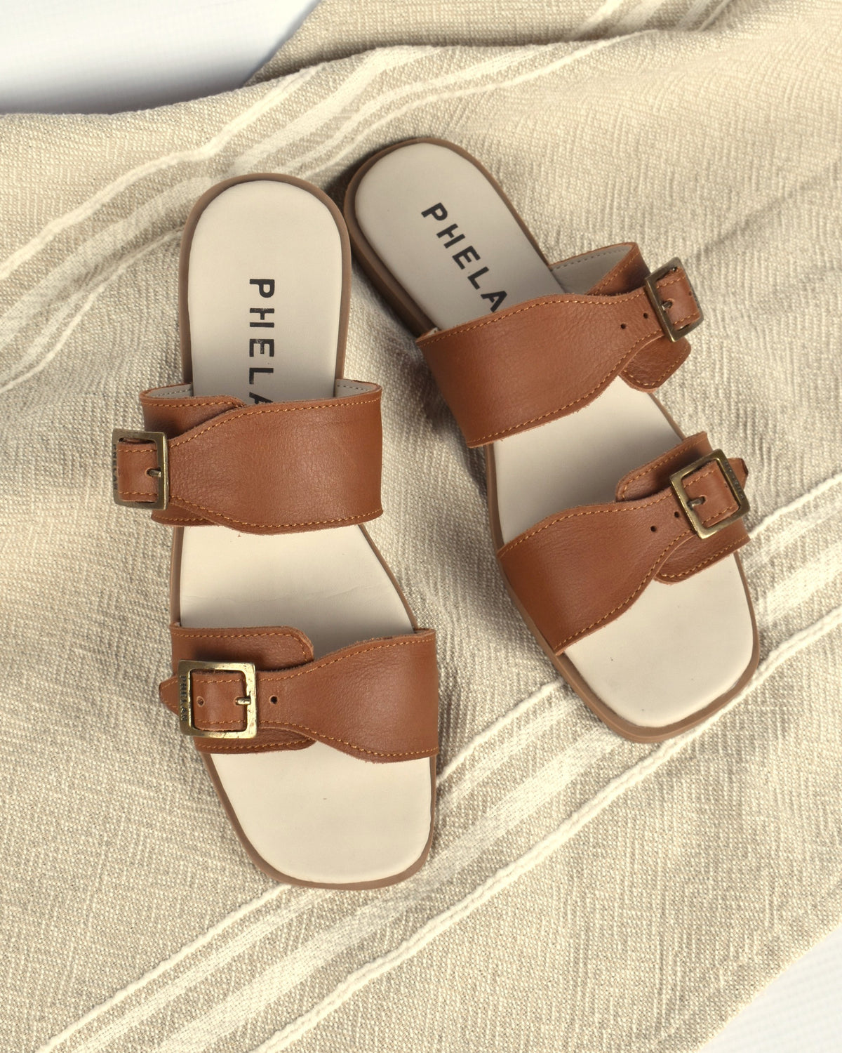 Buckle Sandal in Tan from above, on an oatmeal linen throw