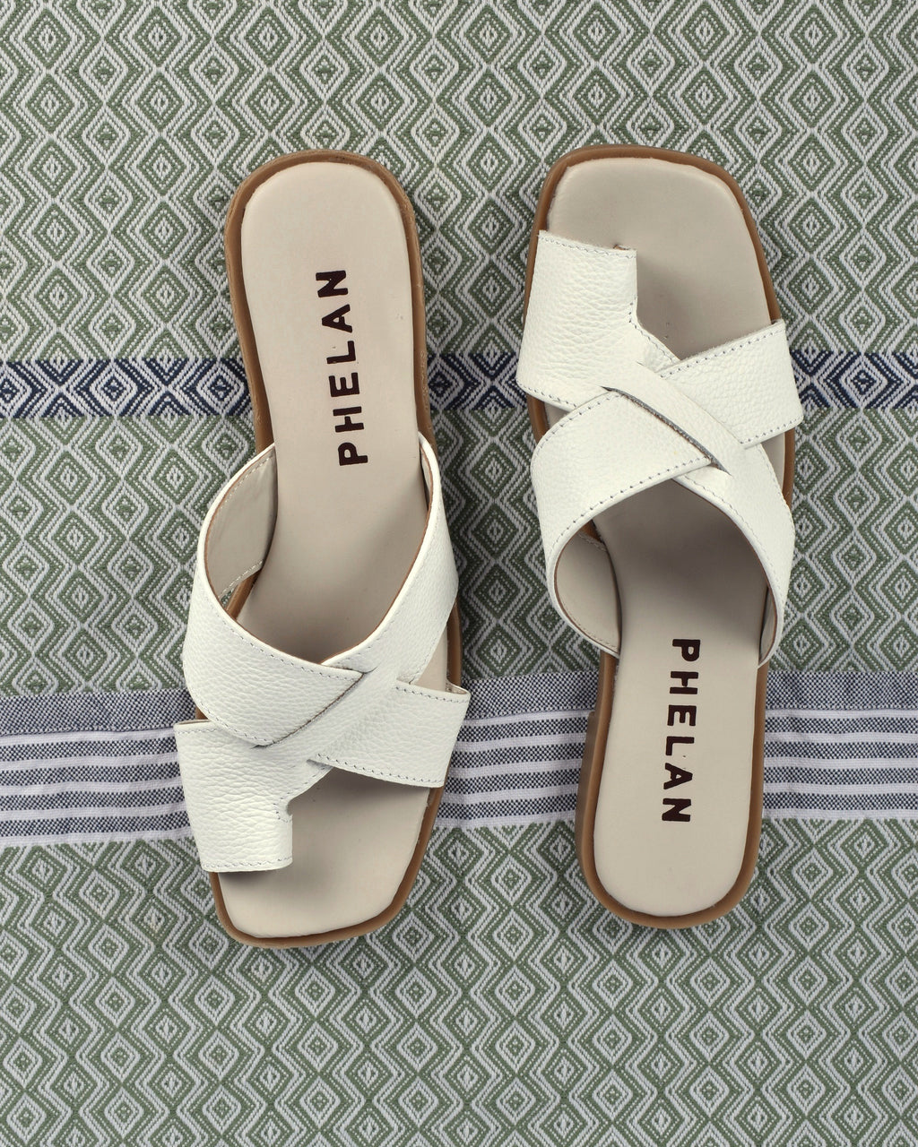 Isla Slide in White, the pair from above on a sage diamond-weave cloth