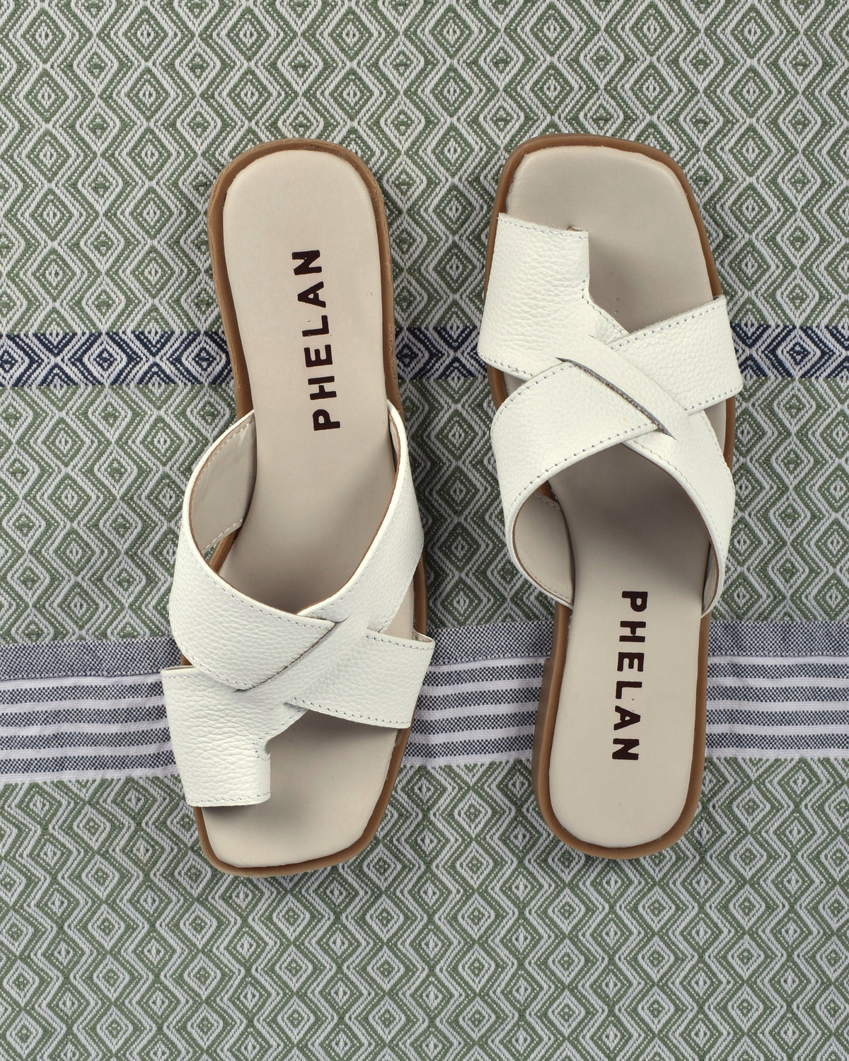 Isla Slide in White, the pair from above on a sage diamond-weave cloth