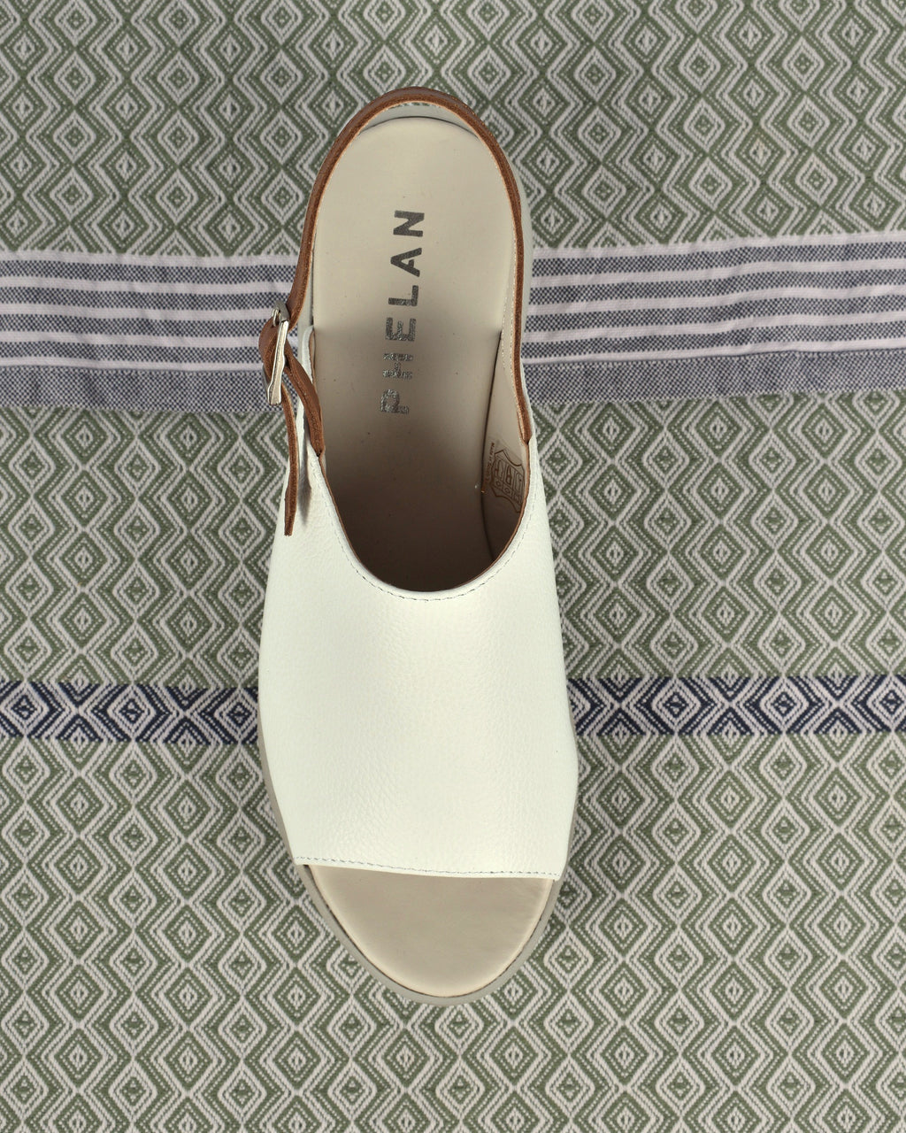 Corsica Platform in White/Tan, one shoe from above on a sage diamond-weave cloth