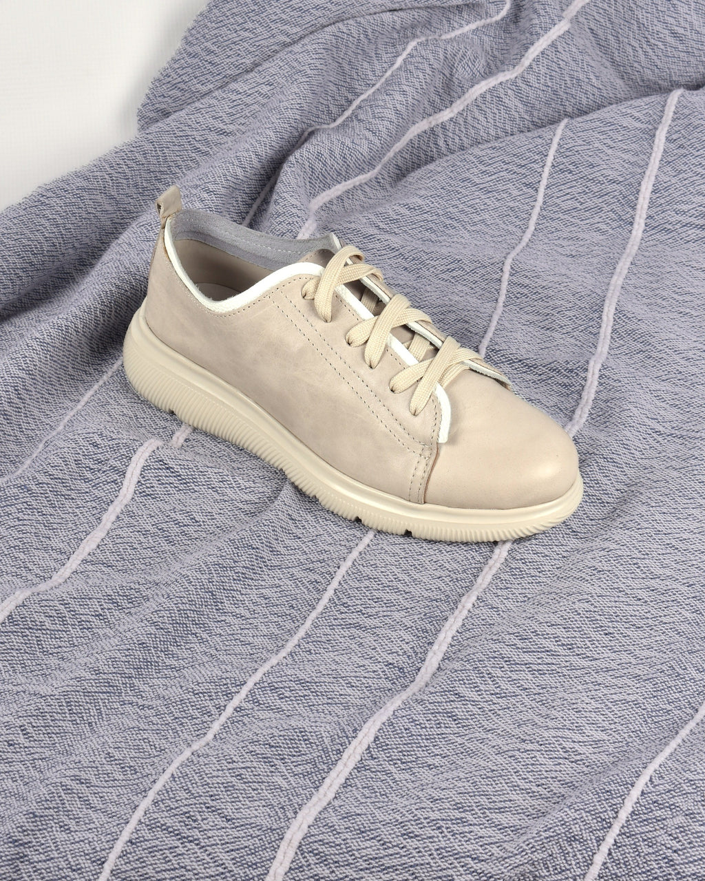 Deck Sneaker in Stone/White on a blue-grey striped throw