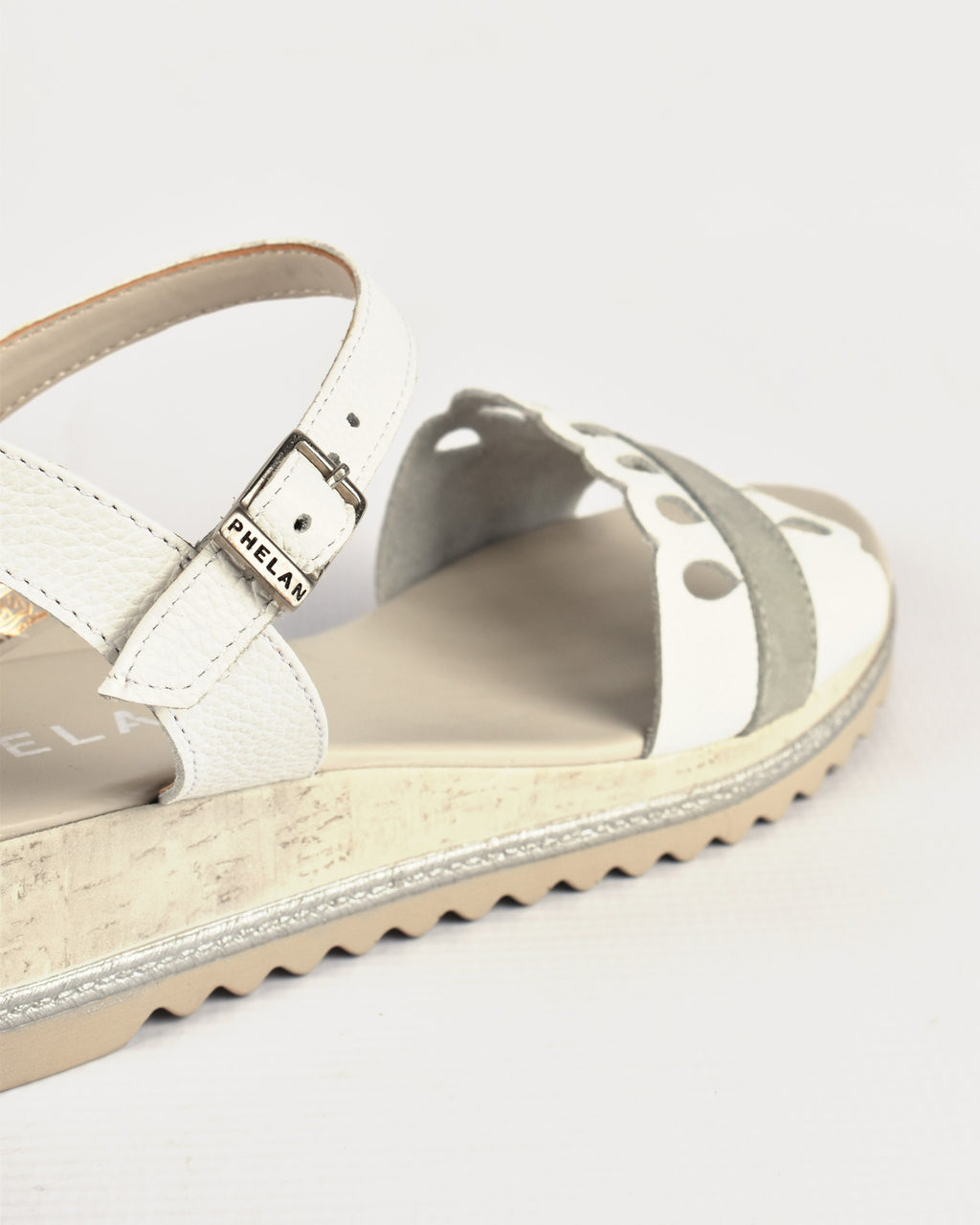 Dolly Wedge in White/Grey, close-up of the PHELAN buckle and cut-outs