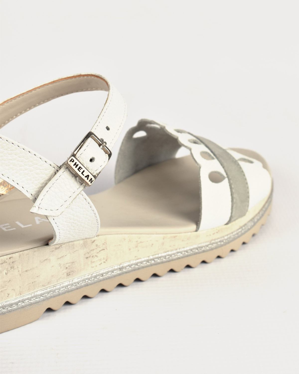 Dolly Wedge in White/Grey, close-up of the PHELAN buckle and cut-outs