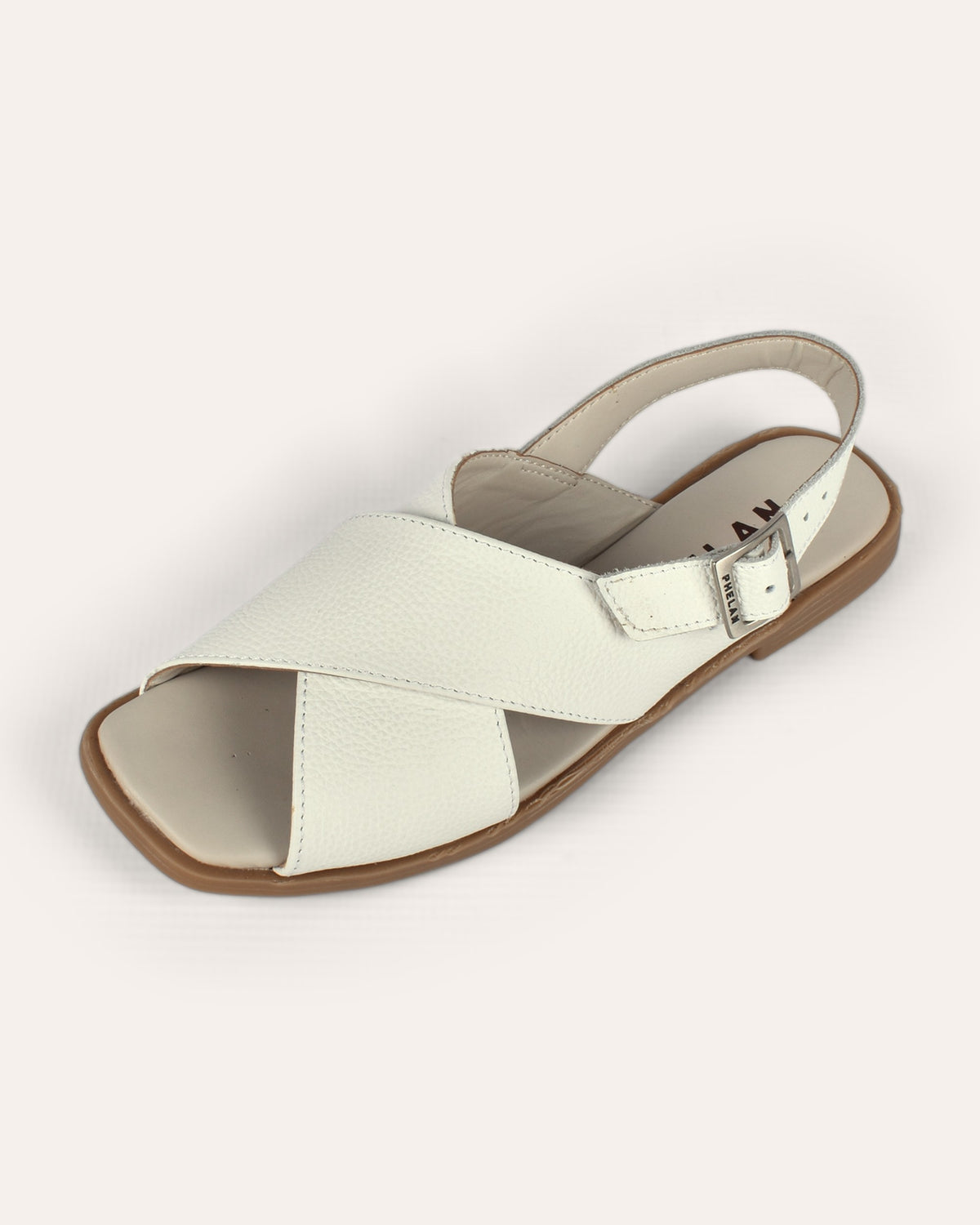 Capri Sandal in White, one shoe from the front, showing the crossover straps and buckled slingback
