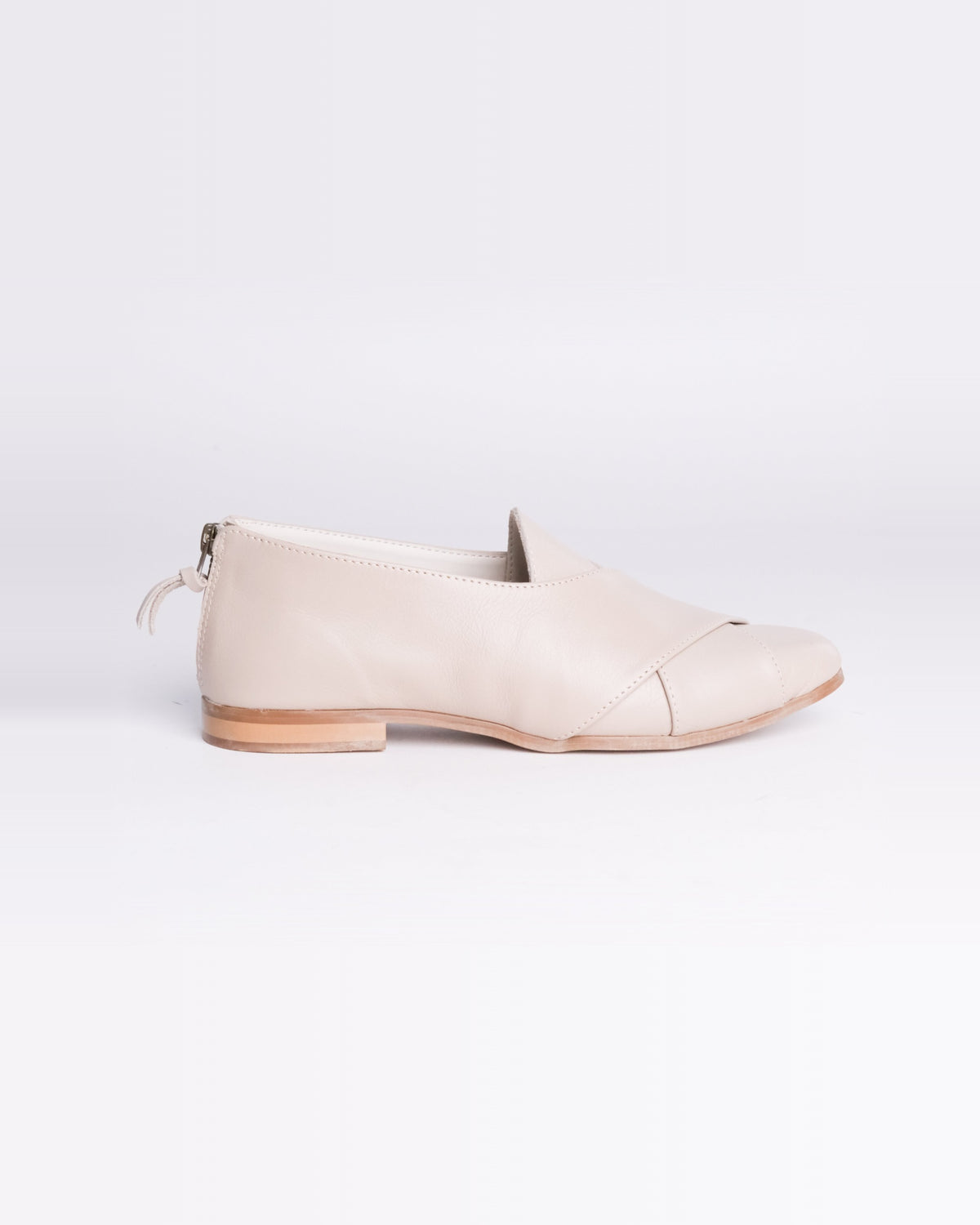 Taupe Crossover Pixie – taupe leather flat with a crossover strap and back zip, side view, handmade by Phelan