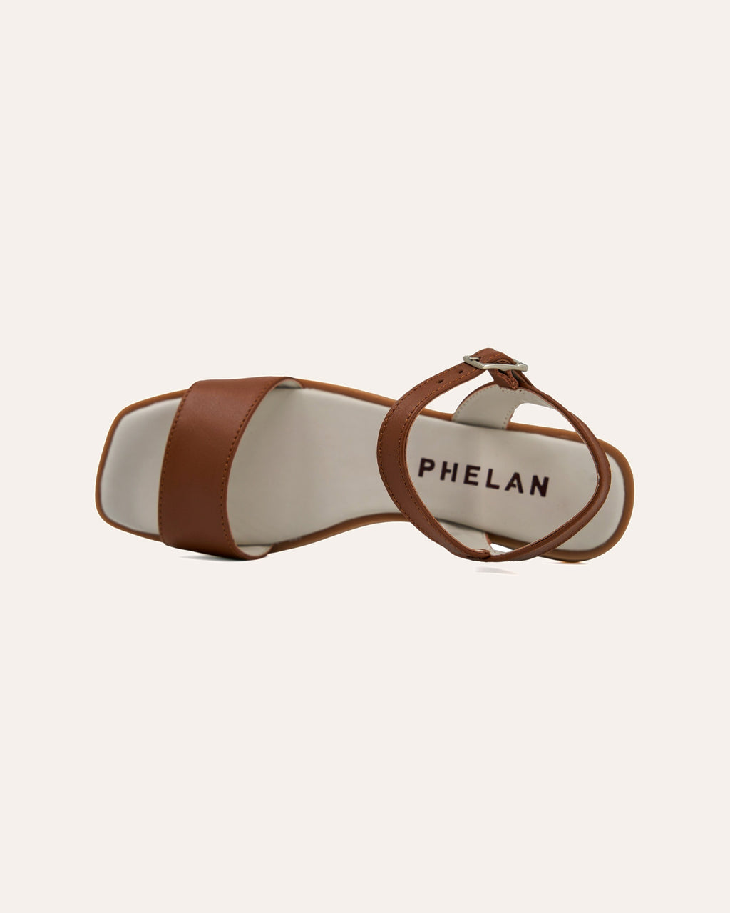 Stella Sandal in Tan close up, with the PHELAN footbed and silver buckle