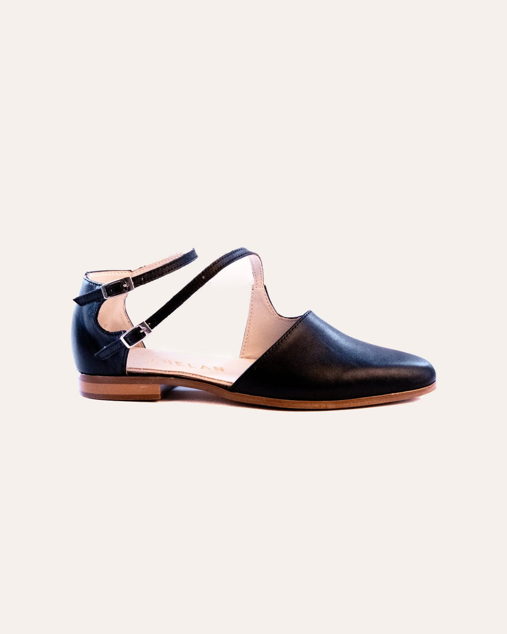 Tumi Flat – black leather flat with open sides and two buckled ankle straps, side view, handmade by Phelan